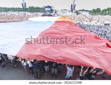 KOSTRZYN NAD ODRA, POLAND - AUGUST 1, 2015: Polish flag spread with audience to commemorate the 71st anniversary of the Warsaw Uprising, during 21th Woodstock Festival Poland (Przystanek Woodstock).