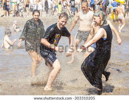 KOSTRZYN NAD ODRA, POLAND - AUGUST 1, 2015: Young people playing in mud pool during 21th Woodstock Festival Poland (Przystanek Woodstock), one of the biggest open air festivals in Europe.