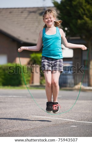 Young girl jumping rope outdoors