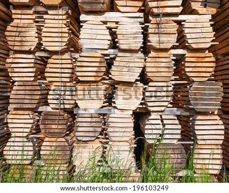 Stack of wooden logs boards at the lumber yard