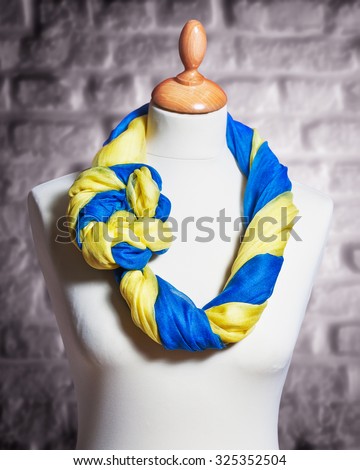 Mannequin with silk cloth. Knitted fashion blue and yellow organza shawls on tailor bust. Single object with clipping path