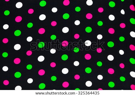 Natural silk texture background. Closeup of black textile with pink, green and white polka dots