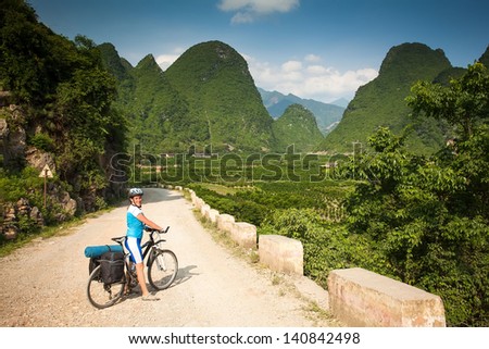 girl on bike rides on Typical landscape in Yangshuo Guilin, China