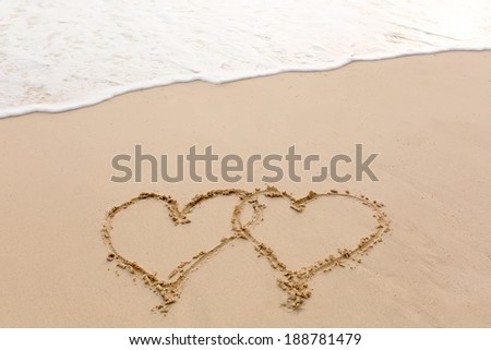 heart outline on the wet brilliance beach sand against wave