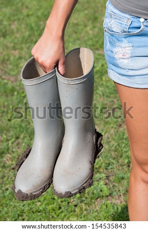 Gray muddy boots holding woman after work.