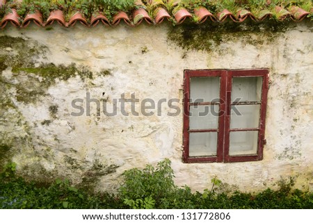 Old and white house with red roof and wooden window. Grunge and horizontal banner