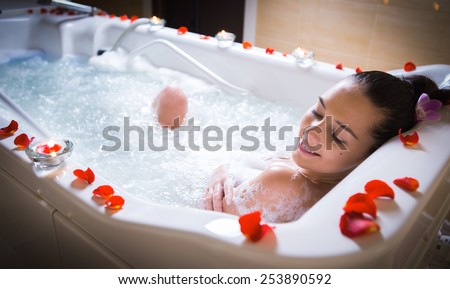 Young woman take bubble bath with candle.