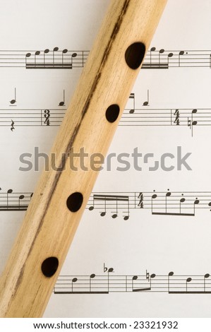 Hand made bamboo flute sits on a sheet of music