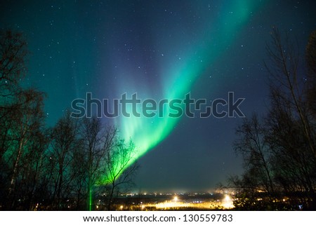 Northern lights and Big Dipper shine brightly over a city