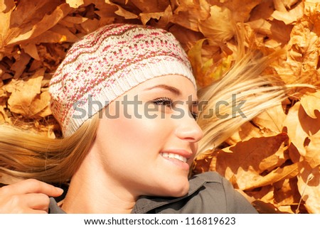 Image of pretty female laying down on old dry tree leaves