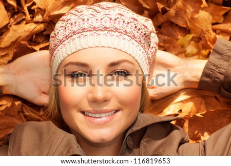 Image of attractive female laying down on the ground in autumn park