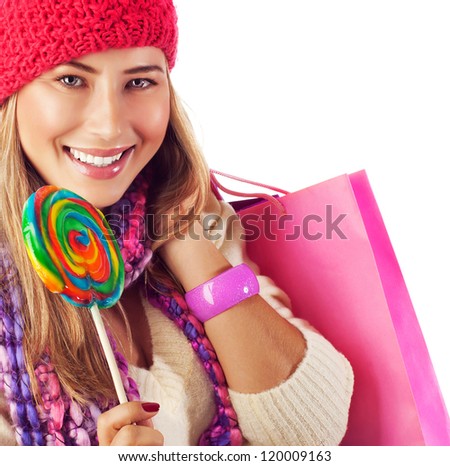 Image of nice blond girl wearing warm winter red hat and eating tasty sugar candy, sweets shop, Christmas present bag, stylish accessories, New Year goody-goody, christmastime holidays