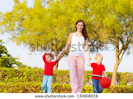 Picture of happy young family in park, cute pregnant mother with two sweet child walking outdoors in spring time, beautiful woman with son and daughter having fun on backyard, love and happiness