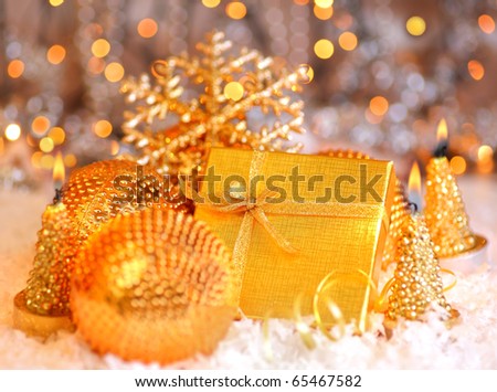 Winter holiday background with golden present gift box, Christmas tree ornament  & candle decoration