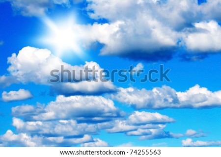 Blue sky background with fluffy clouds & bright sunshine
