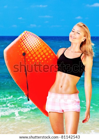 Happy sporty girl playing body board on the beach, summertime fun, vacation, outdoor leisure activities concept