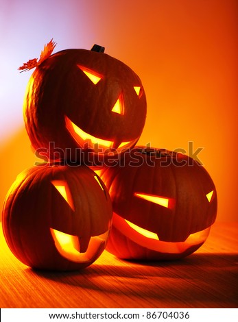 Halloween glowing pumpkins over warm wooden background, autumn holiday, traditional party decoration, fun concept
