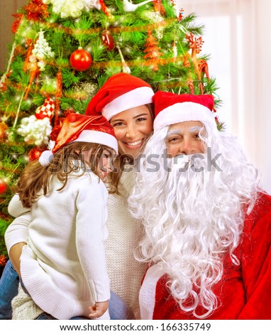 Christmas party, happy family at home celebrating New Year, mother with daughter and Santa claus near Xmas tree, happiness concept