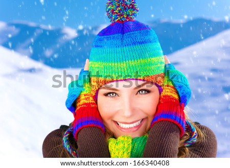 Closeup portrait of pretty woman closing ears from frosty wind, wearing colorful wool hat and gloves, spending winter holidays in the mountains