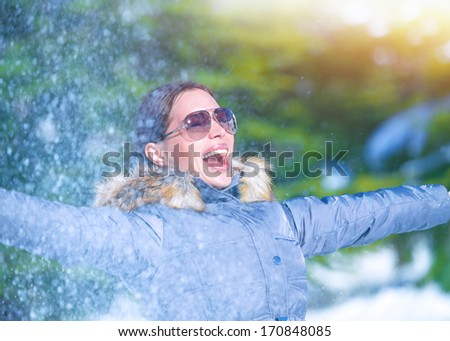 Playful woman having fun on winter park, throwing snow, enjoying wintertime nature, active lifestyle, happiness concept
