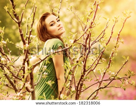 Fairy-tail forest nymph, beautiful sexy woman at spring garden, wearing long dress, sitting on blooming tree, vintage dreamy fashion style