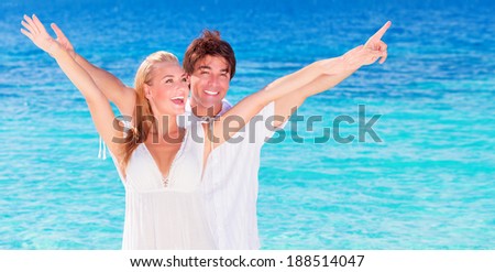 Happy couple playing on the beach, young family in love spending honeymoon vacation on luxury islands, cheerful active young people having fun at summertime travels, joy of life concept