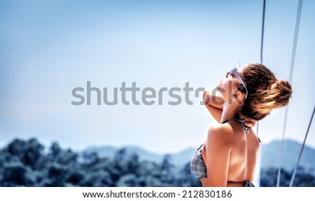 Beautiful young woman sailing on the sea, tanning on the yacht deck, enjoying bright sun light, summer travel and tourism concept