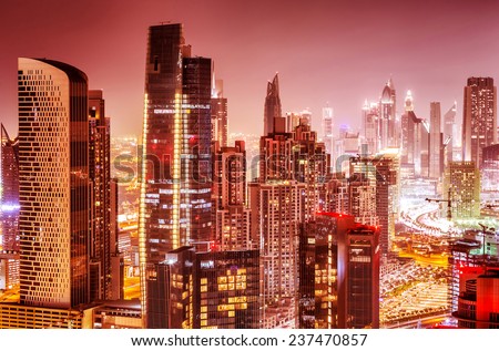 Beautiful background of Dubai at night, gorgeous cityscape over pink sky, many glowing lights of tall skyscrapers, luxury modern expensive architecture design