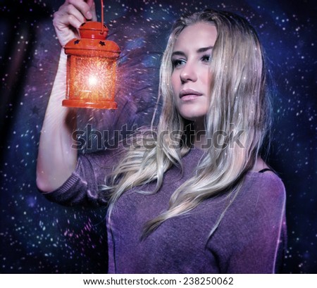 Closeup portrait of beautiful woman with glowing lantern in hands over starry sky, magical Christmas night, fashion concept