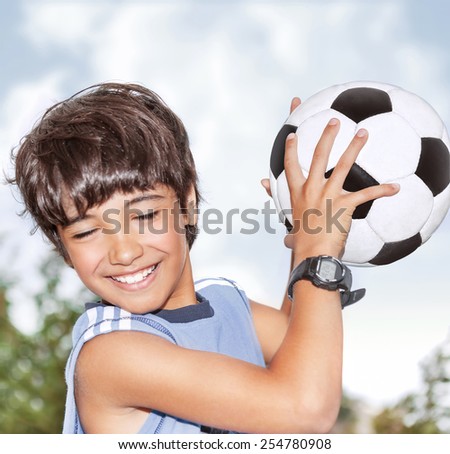 Active happy boy in motion, having fun outdoor, playing football in sportive summer camp, catching ball, best goalkeeper in football team