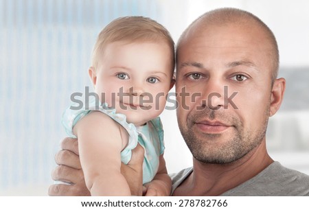 Closeup portrait of a handsome dad with cute little daughter on hands, spending time at home, happy fathers day theme