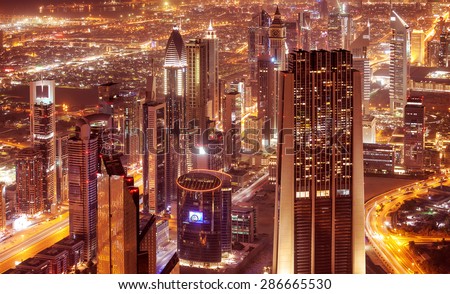 Dubai city at night, beautiful modern buildings glowing lights, bird eye view on gorgeous cityscape, famous business and travel destination, United Arab Emirates