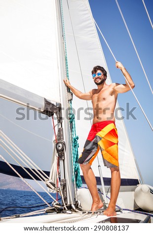 Happy man having fun on sailboat, enjoying active summer adventure, luxury beach holidays, sportive lifestyle