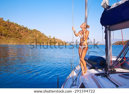 Sexy woman on sailboat, pretty girl with perfect body tanning on the deck of water transport, active beach holidays, enjoying summer vacation