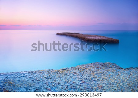 Beautiful blue and pink sunset over sea, amazing landscape of rock coast, wonderful destination for summer romantic vacation