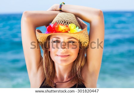 Portrait of beautiful girl on the beach, wearing sun hat with colorful flowers decoration, having fun on beach party, happy summer holidays