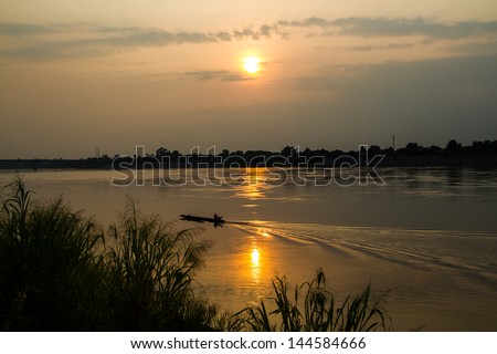 Sunset at Mekong river with boat running.
