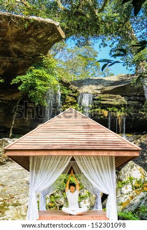 Model have yoga session in front of  the waterfall .