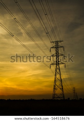 Electric transmission tower with sunset light blackground.