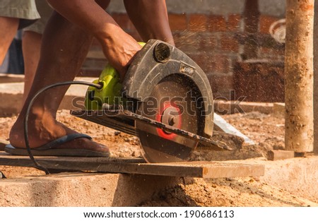 Electric saw cutting wood for construction.