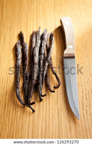vanilla pods with knife on wooden table