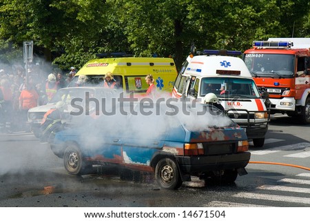 firemen with a burning car