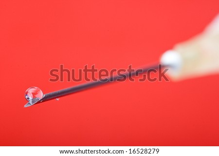 detail of syringe with drop on the top