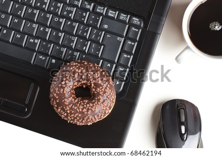 the break in the  office . doughnut on laptop keyboard