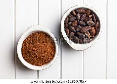 top view of cocoa beans and cocoa powder in bowls
