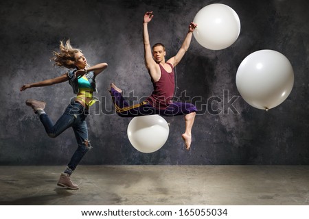 Energetic couple dance/A pair of dancers in a jump in the arrangement with the big balloons