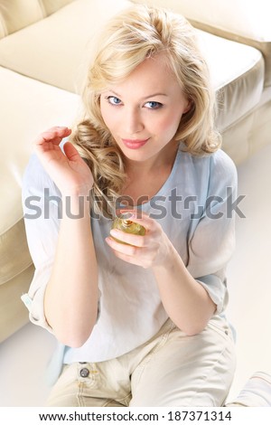 Woman with perfume bottle . Form of a beautiful blonde holding in his hand a bottle of perfume
