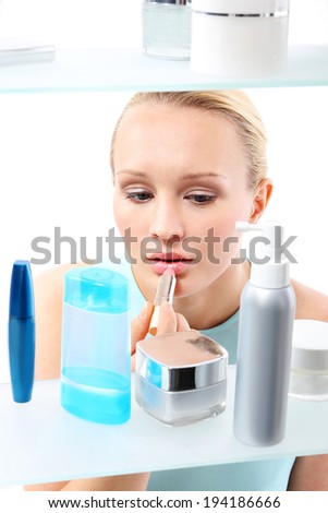 Shopping frenzy - a woman in a cosmetic shop.  A woman stands at the client shelf and selects cosmetics