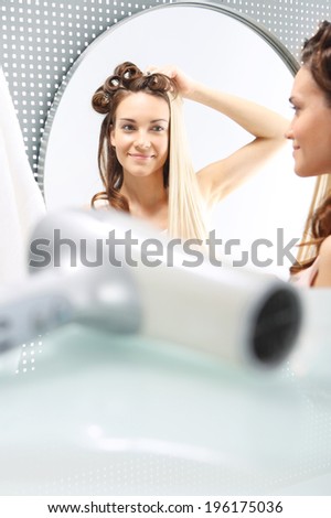 Hair care, coloring, straightening.  Woman with hair standing in front of a mirror. Changing hair color. Full colored hair.