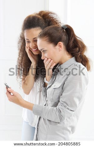 Friends, good news, success .Friendship - friends learn to read message .Two women with mobile phone